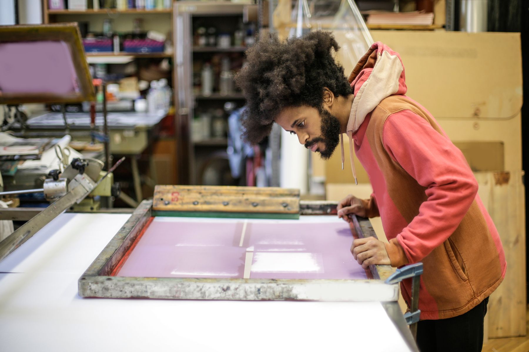 En producent læner sig over et serigrafi i sit værksted