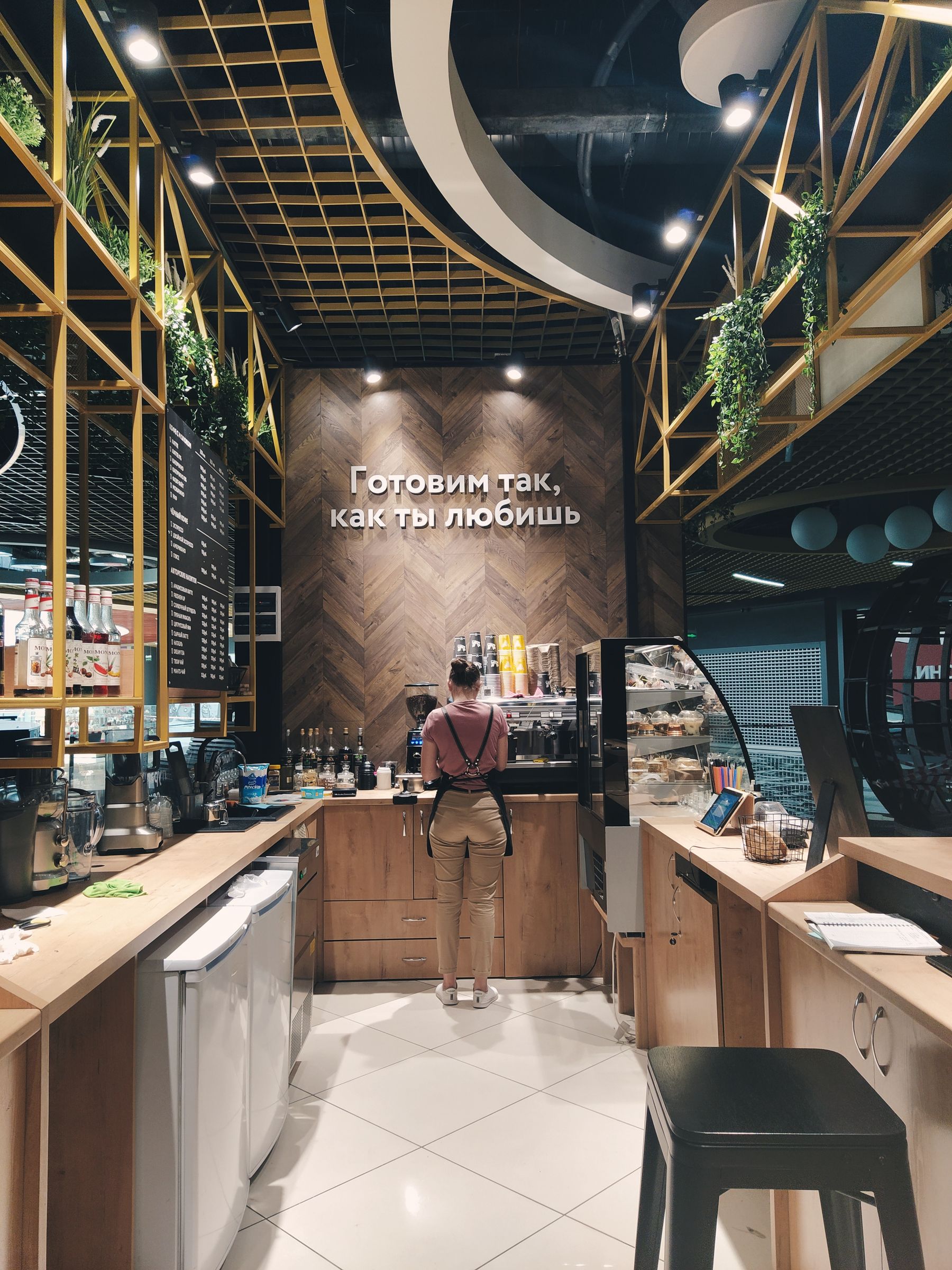 Un café avec un employé, un comptoir et un éclairage chaleureux