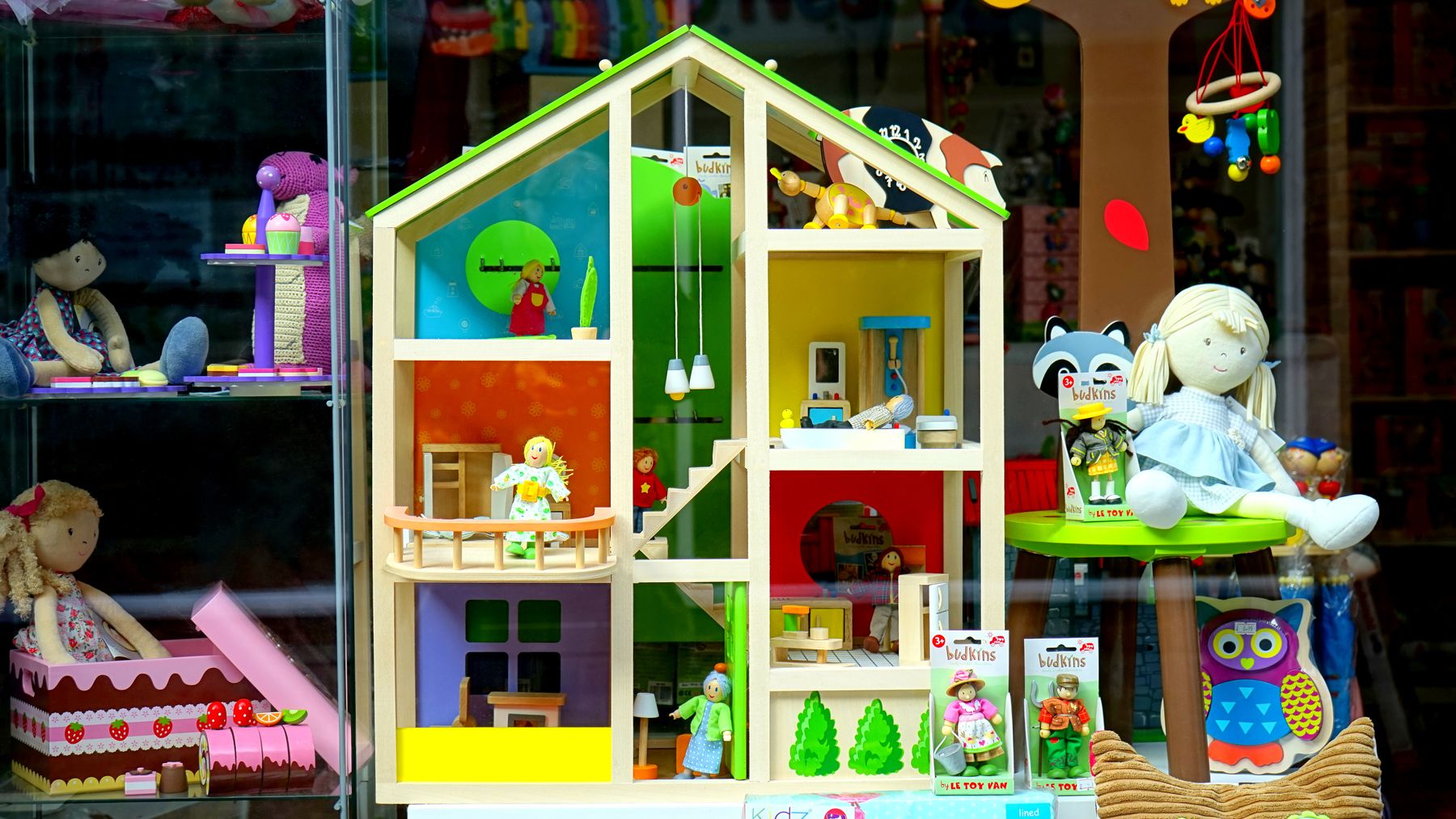 Une maison de poupée en bois et des jouets dans une vitrine