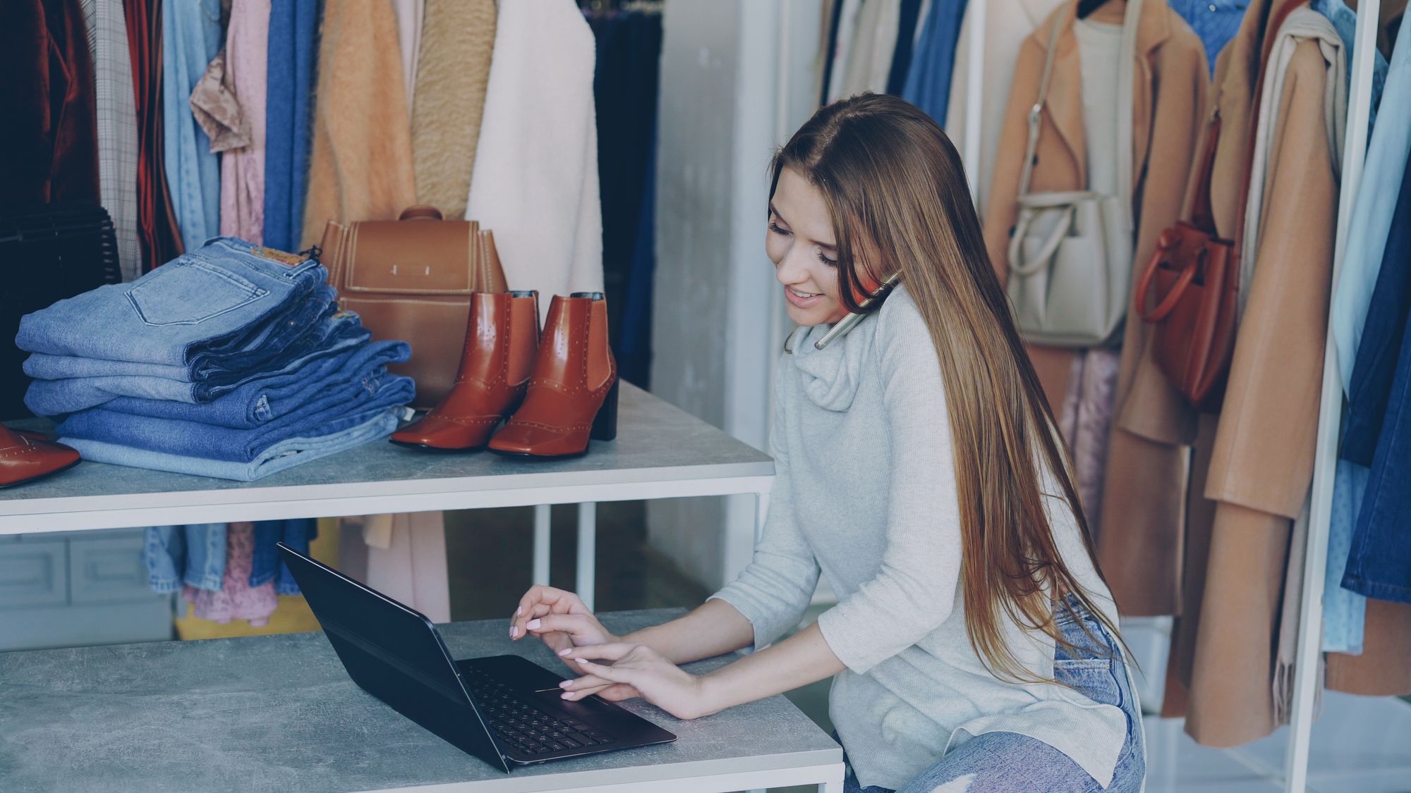 Virksomhedsejeren gennemgår butiksoplysninger på sin bærbare computer
