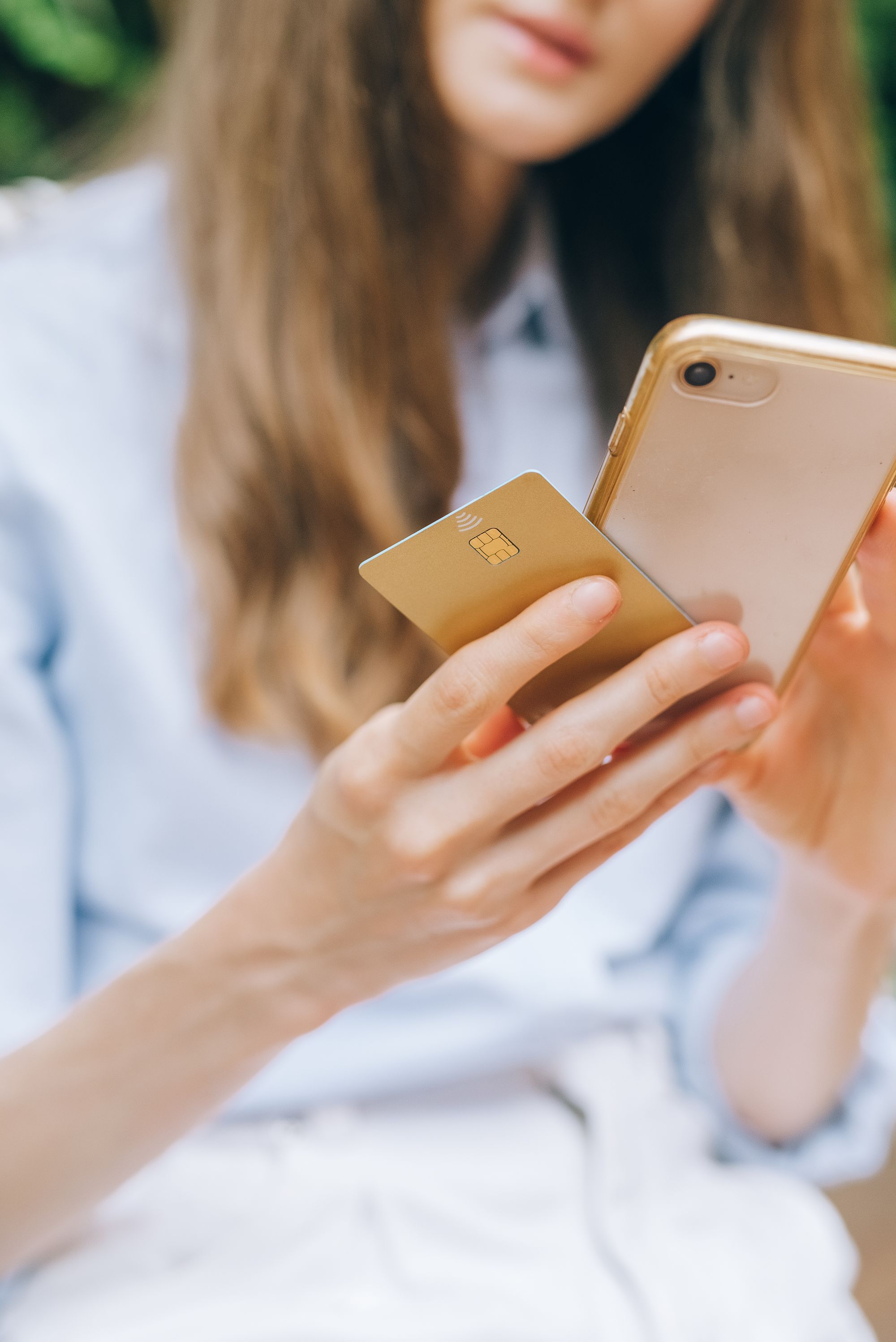 Hænder, der holder en telefon og betalingskort