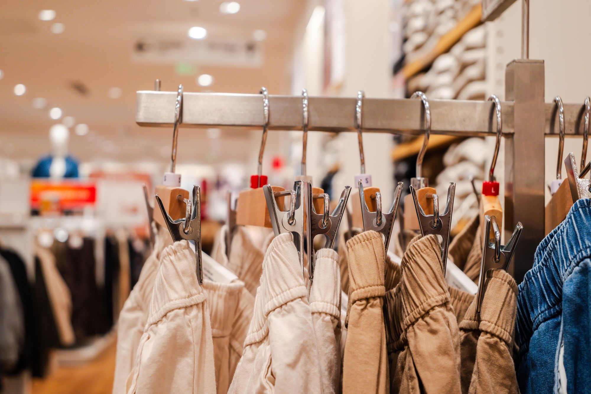 Détail d'un pantalon sur cintres dans un magasin