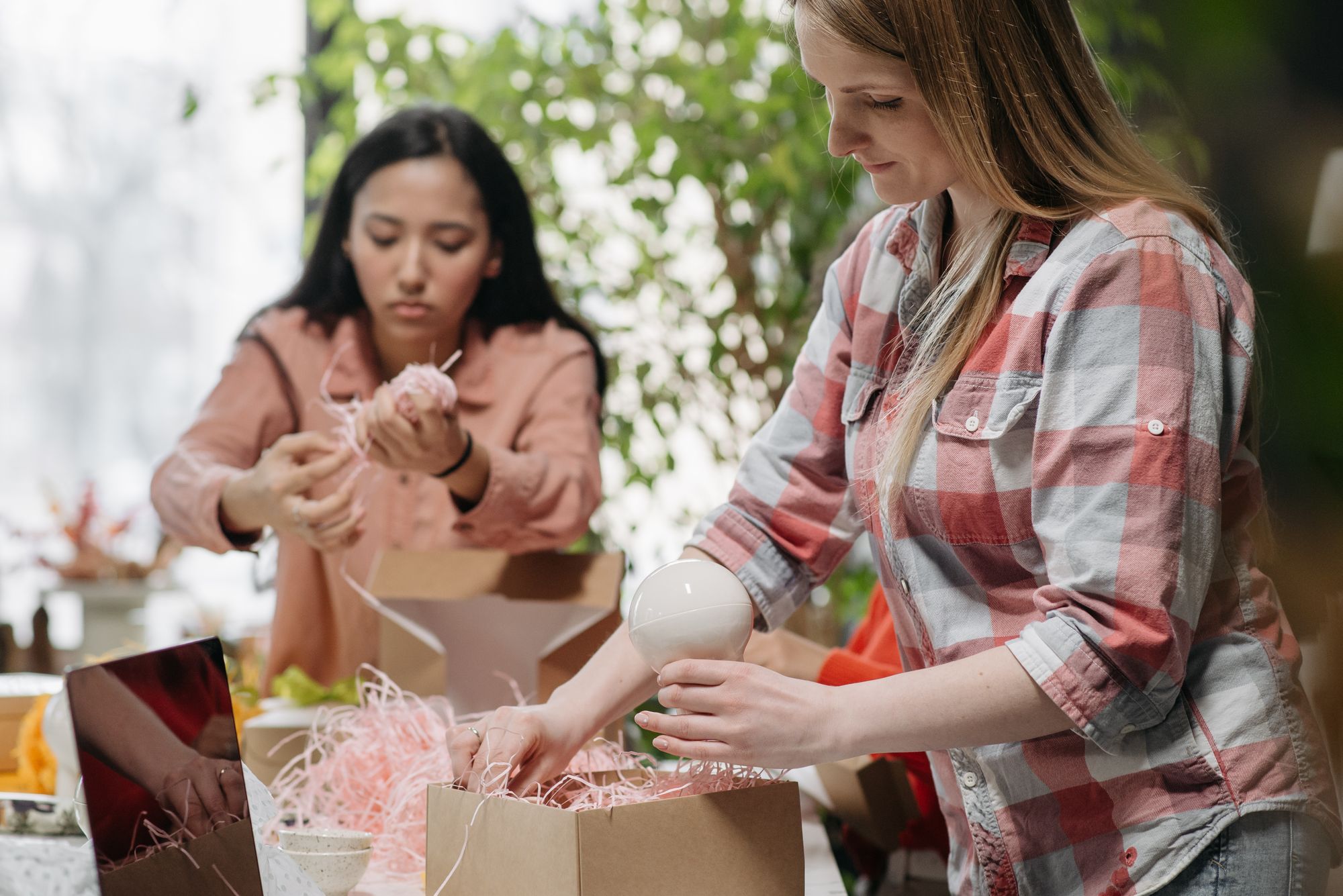 Deux femmes emballant des produits dans des boîtes en carton