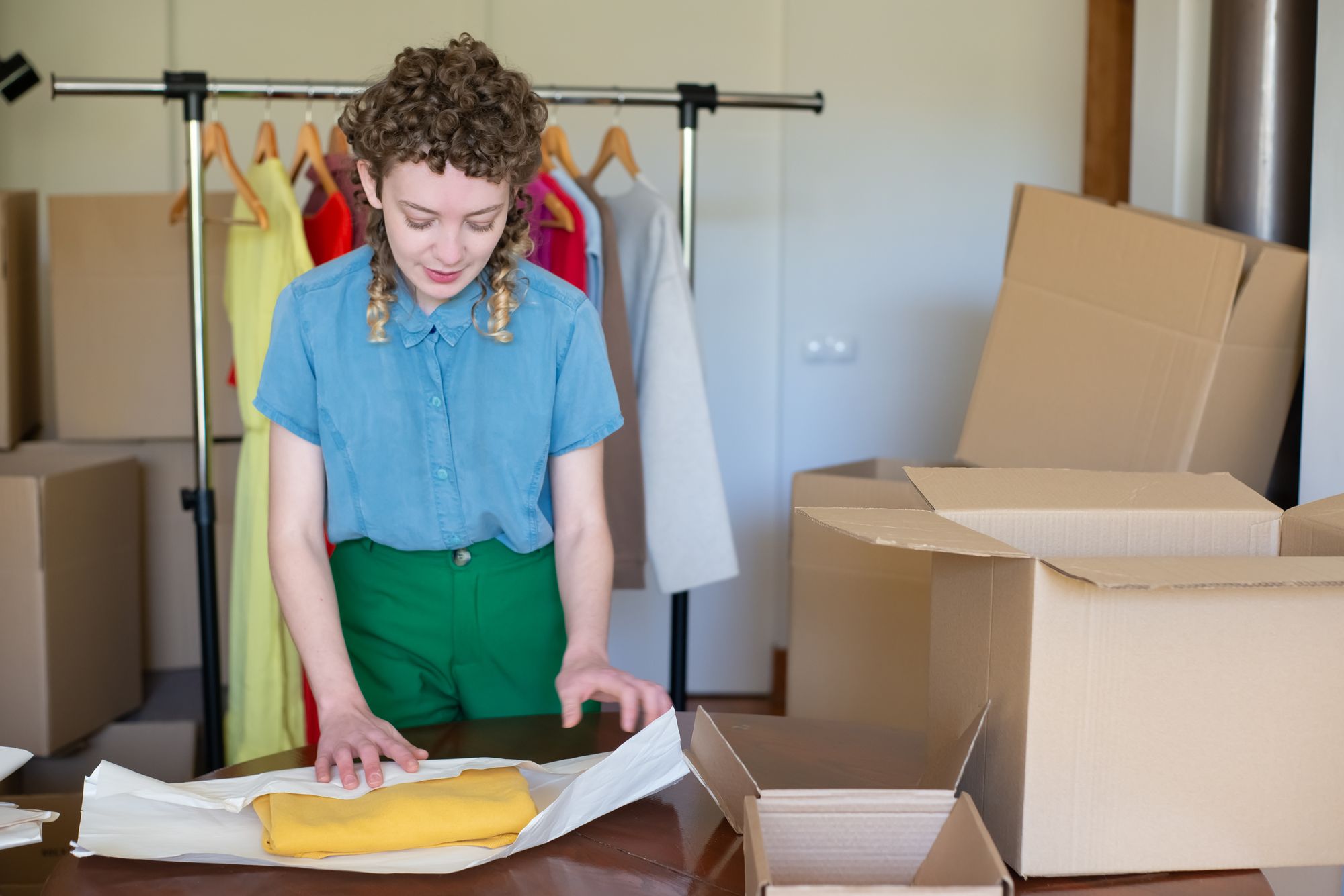 Propriétaire d'entreprise emballant des vêtements dans une boîte en carton